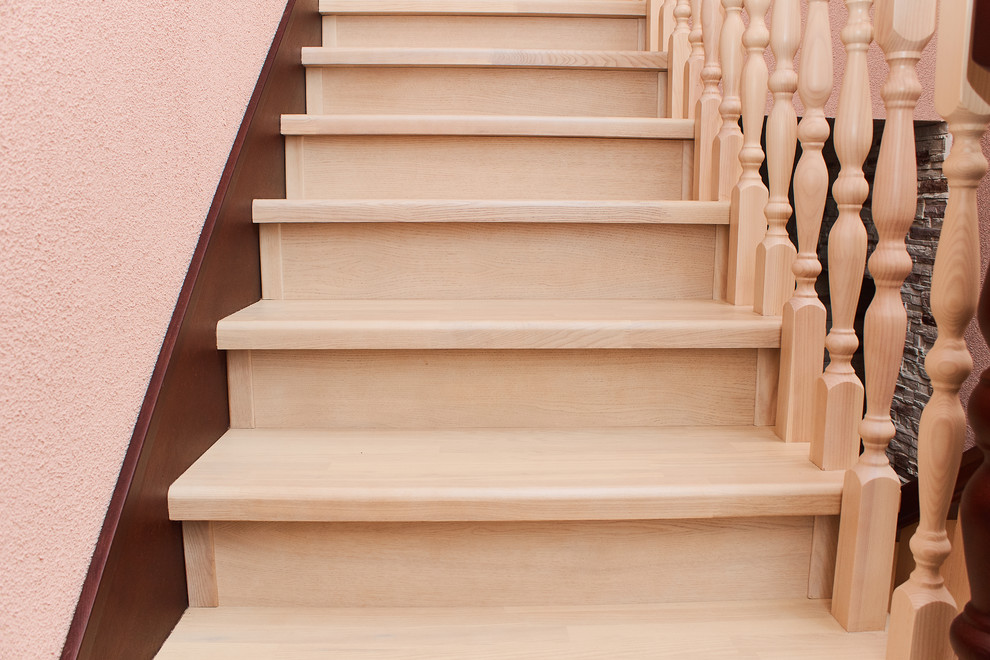 Стильный дизайн: п-образная деревянная лестница с деревянными ступенями и деревянными перилами - последний тренд