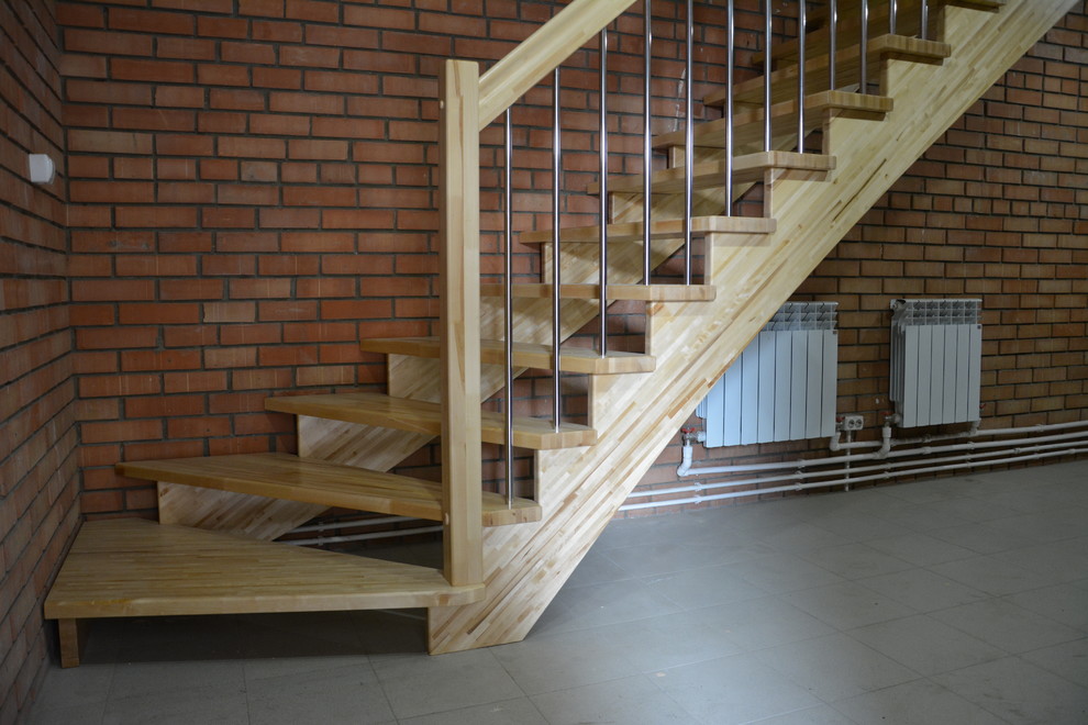 На фото: угловая деревянная лестница среднего размера в стиле лофт с деревянными ступенями и перилами из смешанных материалов с