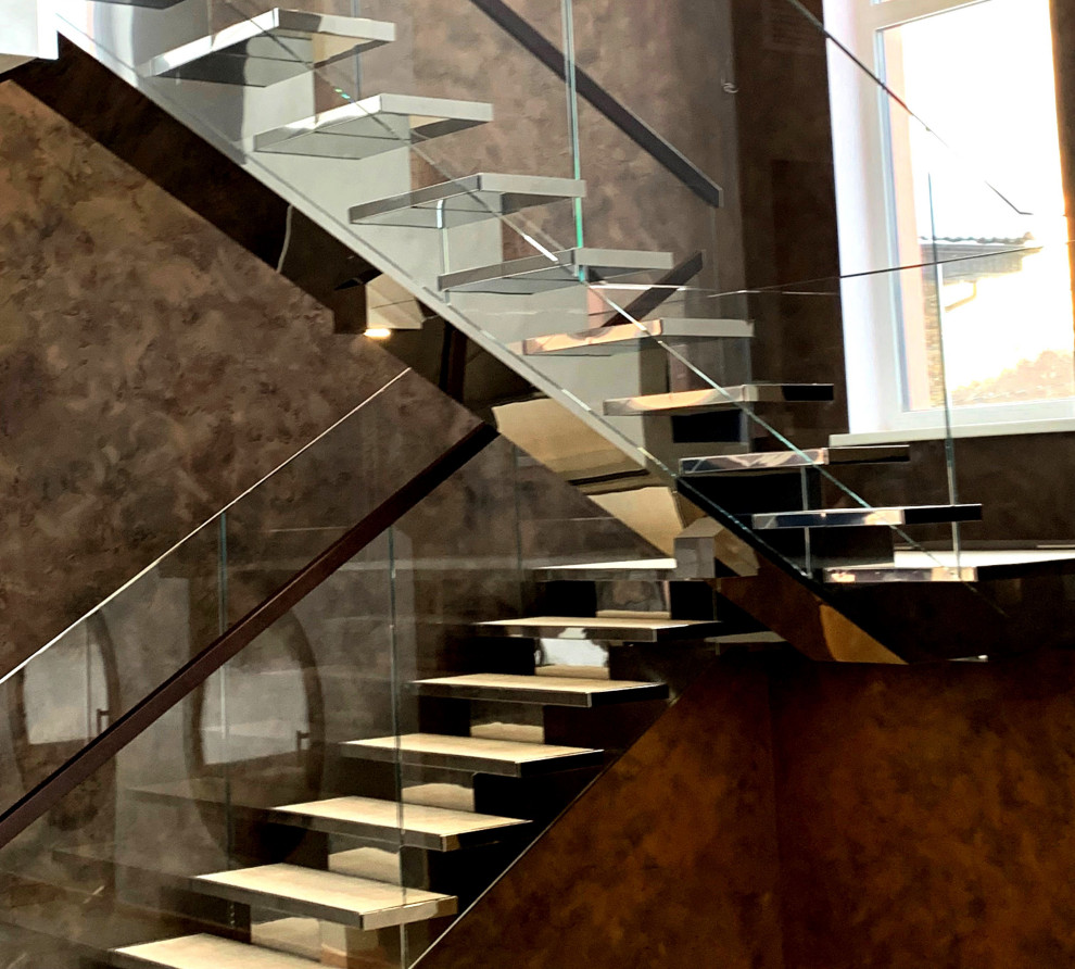 На фото: п-образная лестница в стиле неоклассика (современная классика) с деревянными ступенями и стеклянными перилами