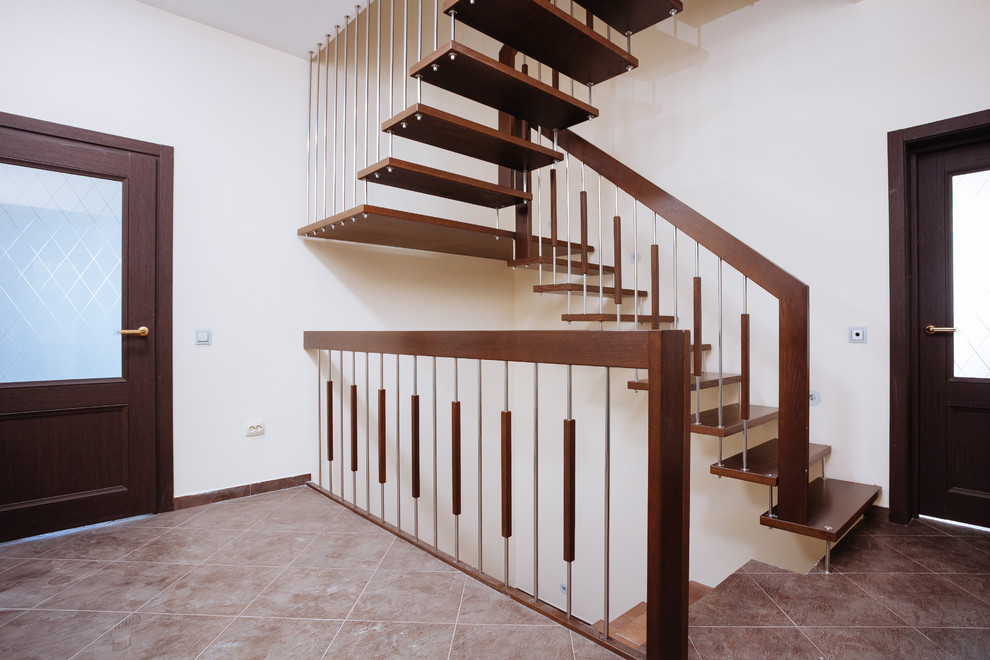 На фото: п-образная лестница среднего размера в современном стиле с деревянными ступенями и перилами из смешанных материалов