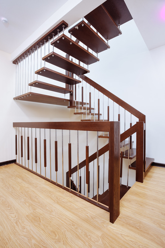 Cette photo montre un escalier tendance en U de taille moyenne avec des marches en bois et un garde-corps en matériaux mixtes.