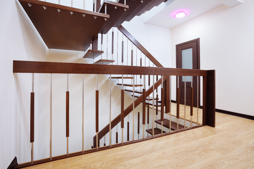На фото: п-образная лестница среднего размера в современном стиле с деревянными ступенями и перилами из смешанных материалов с