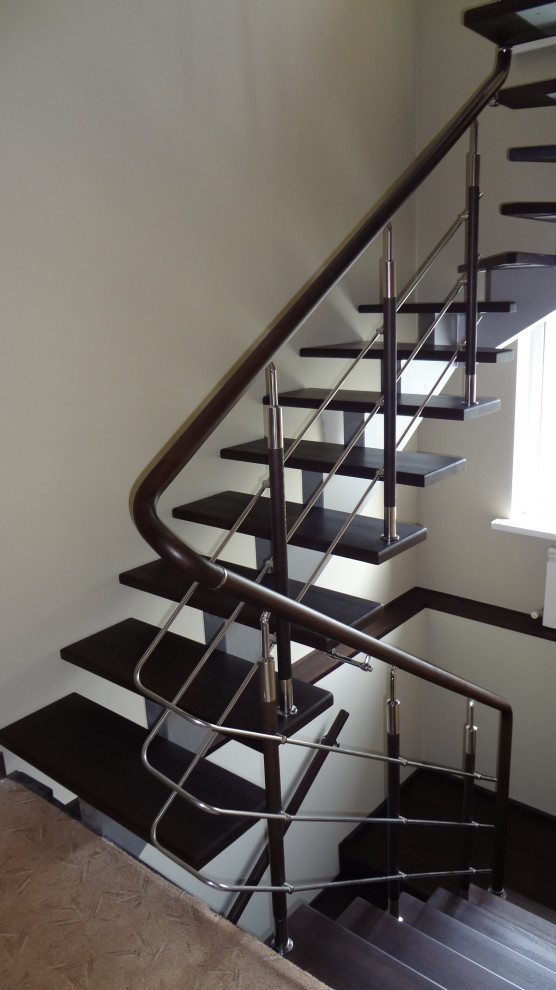 На фото: большая п-образная лестница в стиле лофт с деревянными ступенями и деревянными перилами с