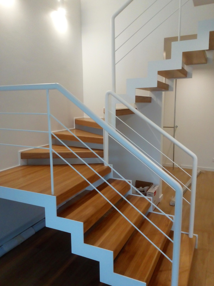 На фото: п-образная лестница среднего размера в стиле лофт с деревянными ступенями и металлическими перилами