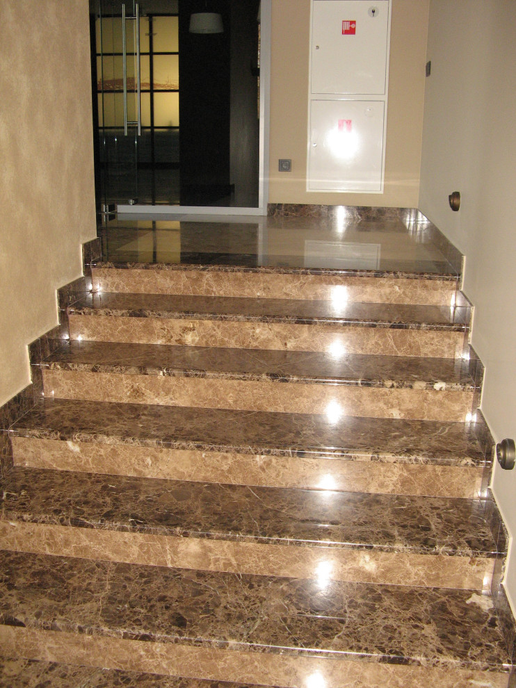 Cette image montre un grand escalier droit traditionnel en marbre avec des contremarches en marbre.