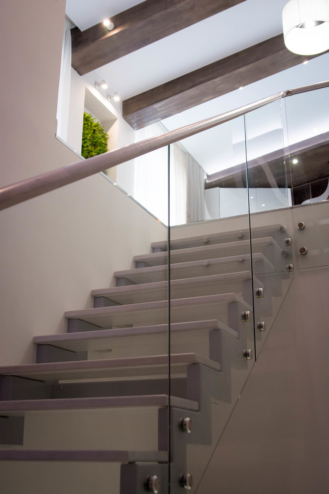 Свежая идея для дизайна: большая п-образная лестница в современном стиле с деревянными ступенями и стеклянными перилами - отличное фото интерьера