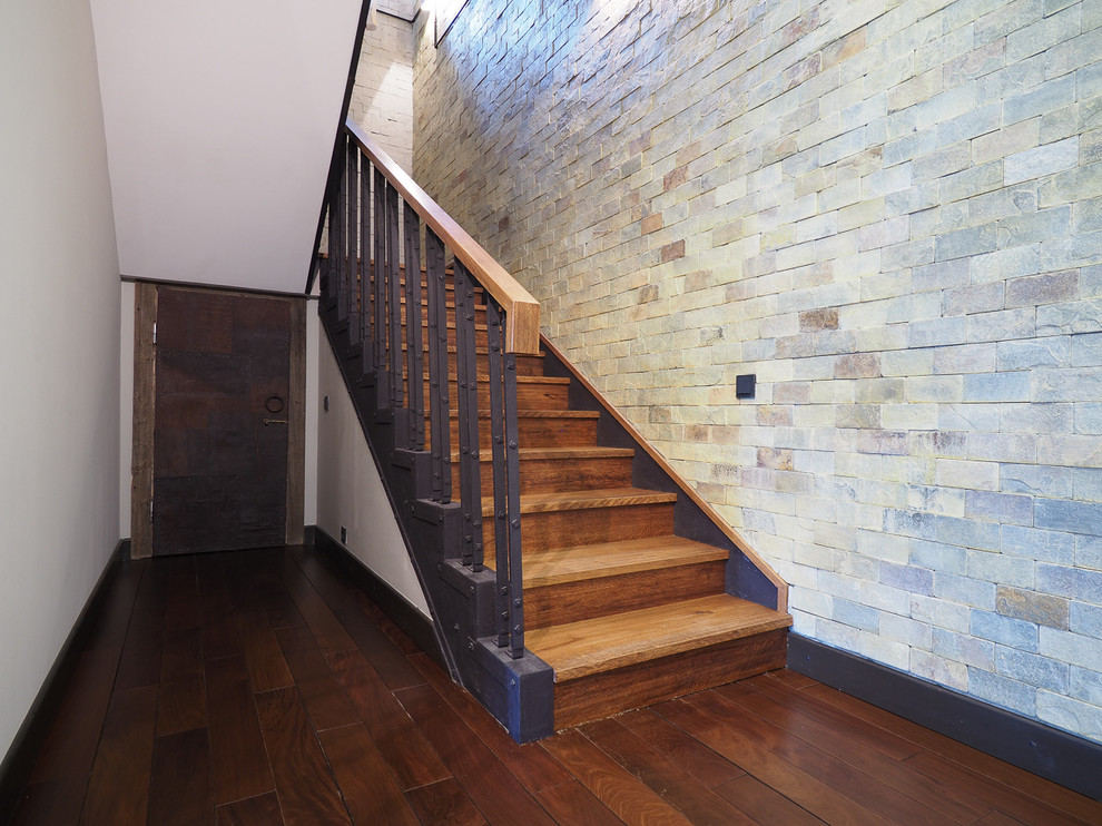На фото: п-образная деревянная лестница среднего размера в стиле лофт с деревянными ступенями и металлическими перилами с