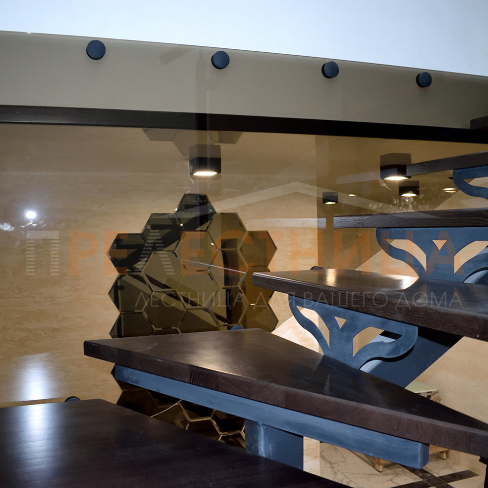 На фото: п-образная металлическая лестница среднего размера с крашенными деревянными ступенями и стеклянными перилами с