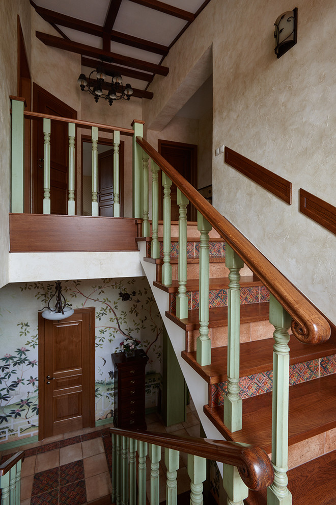 Пример оригинального дизайна: п-образная лестница в стиле кантри с деревянными ступенями, подступенками из плитки и деревянными перилами