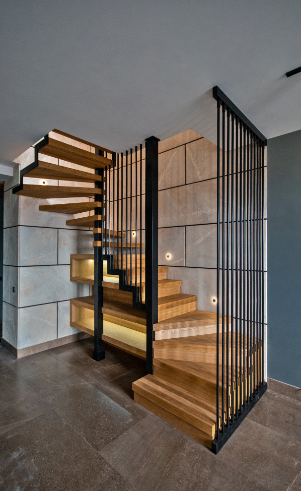На фото: п-образная деревянная лестница среднего размера в современном стиле с деревянными ступенями, металлическими перилами и панелями на стенах с