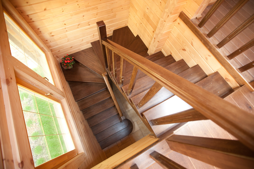 На фото: п-образная деревянная лестница среднего размера в стиле кантри с деревянными ступенями и деревянными перилами