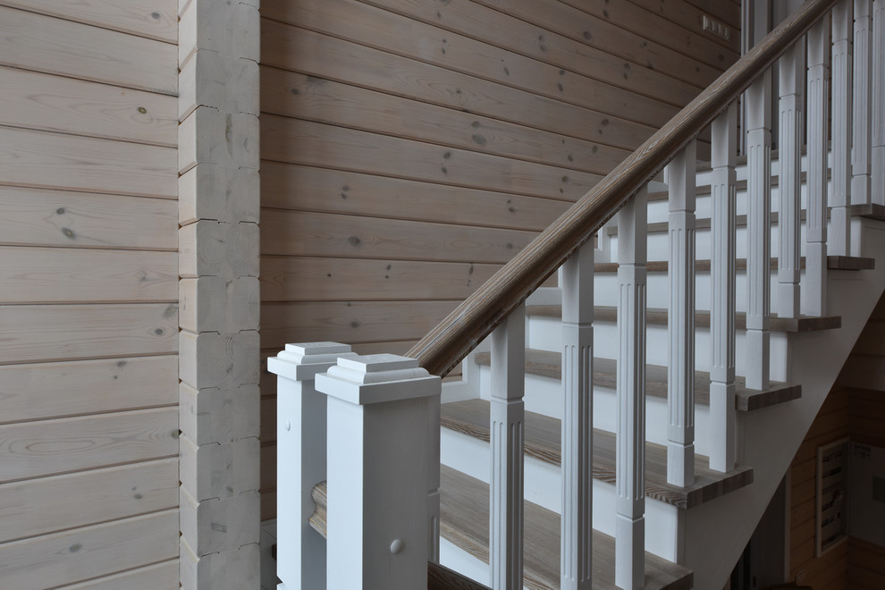 Ejemplo de escalera en U de estilo de casa de campo de tamaño medio con escalones de madera, contrahuellas de madera y barandilla de madera