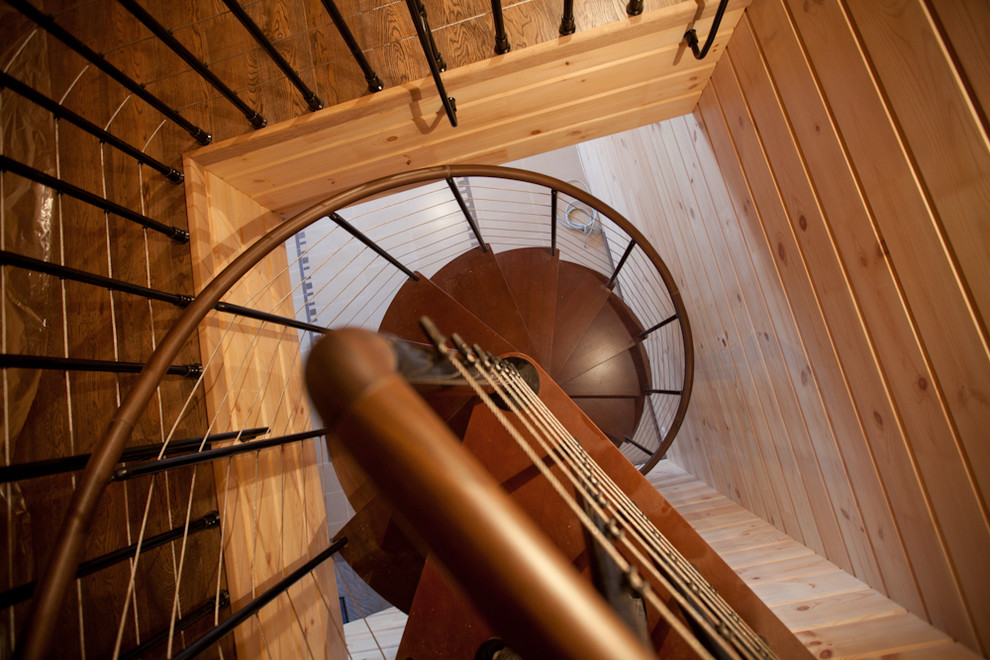 На фото: маленькая винтовая лестница в стиле кантри с деревянными ступенями и деревянными перилами для на участке и в саду с