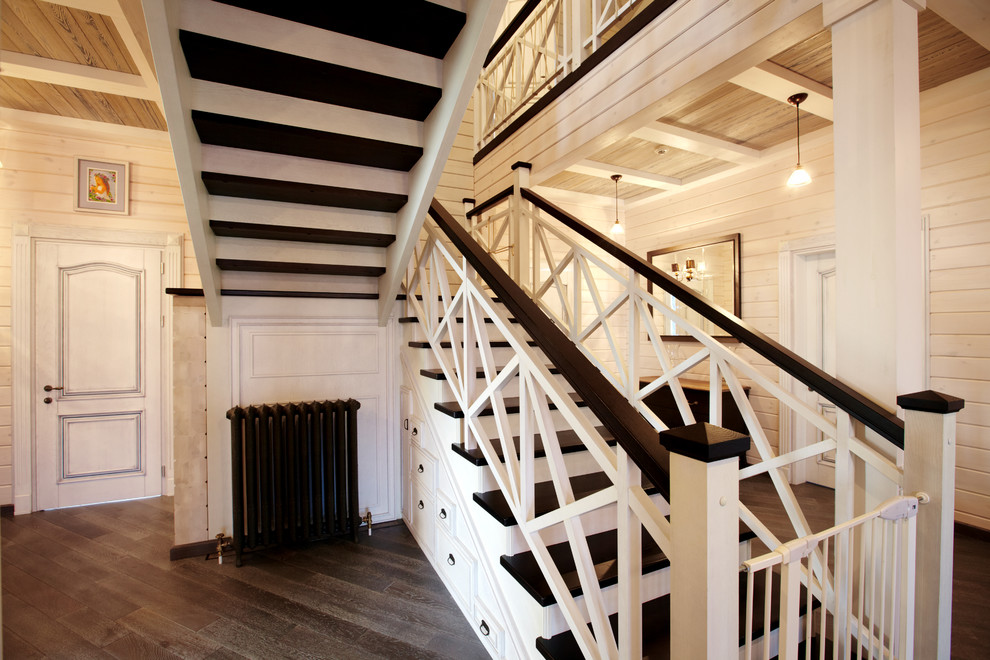 Foto de escalera en U de estilo de casa de campo grande con escalones de madera, contrahuellas de madera y barandilla de madera