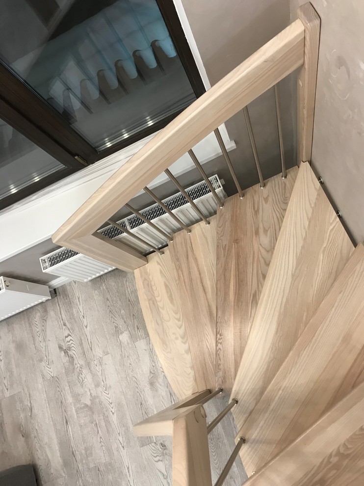 На фото: деревянная лестница на больцах, среднего размера в стиле неоклассика (современная классика) с деревянными ступенями и перилами из смешанных материалов с