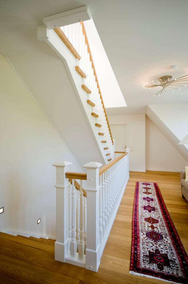 На фото: лестница в классическом стиле с деревянными ступенями и деревянными перилами