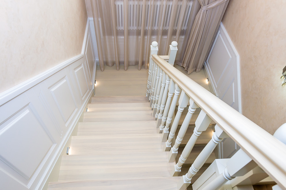 Photo of a large classic wood u-shaped wood railing staircase in Saint Petersburg with wood risers and panelled walls.