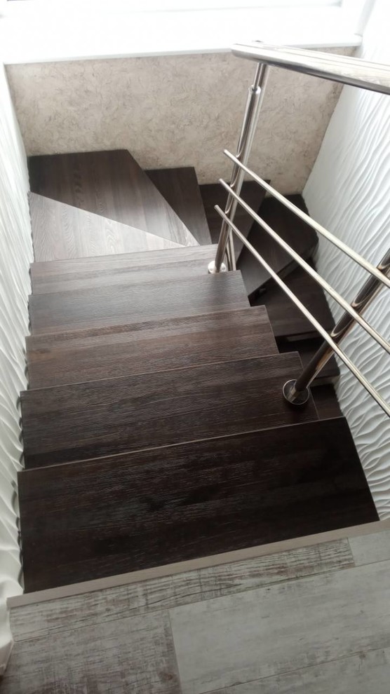 Photo of a traditional wood staircase in Other with wood risers.