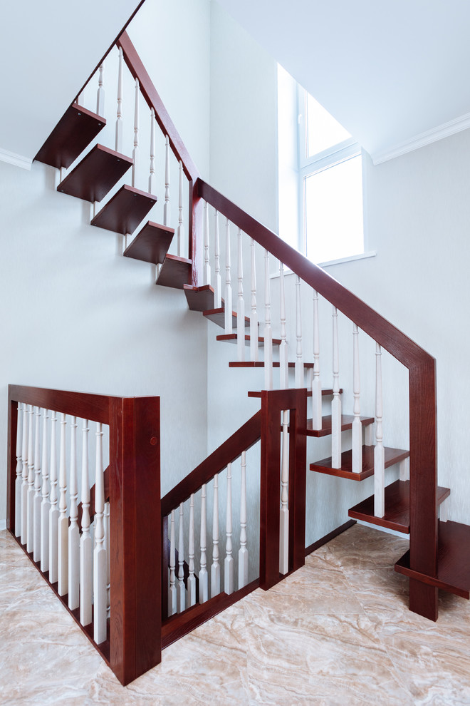 他の地域にあるお手頃価格の中くらいなトランジショナルスタイルのおしゃれなスケルトン階段 (木材の手すり) の写真