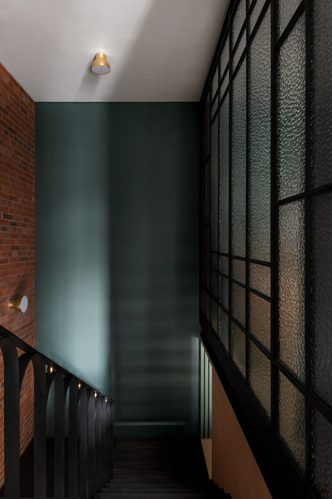 На фото: угловая металлическая лестница среднего размера в стиле модернизм с металлическими ступенями, металлическими перилами и кирпичными стенами с