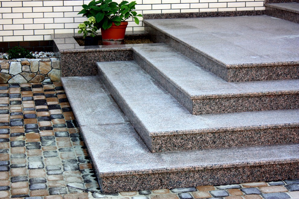 Imagen de escalera grande con escalones de mármol y contrahuellas con baldosas y/o azulejos