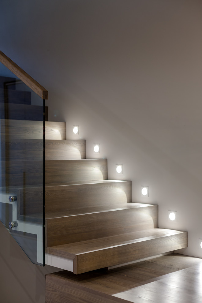 Idées déco pour un grand escalier contemporain en L avec des marches en bois, des contremarches en bois et un garde-corps en verre.