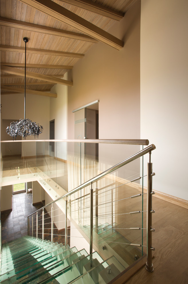 Стильный дизайн: прямая лестница в стиле неоклассика (современная классика) с стеклянными ступенями и перилами из смешанных материалов - последний тренд