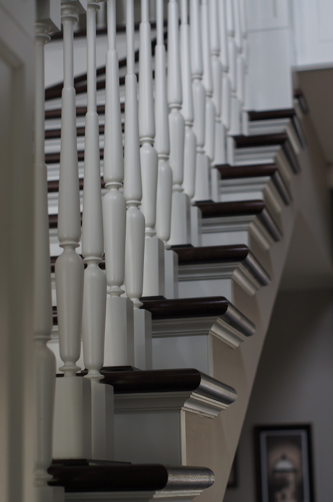 На фото: большая п-образная деревянная лестница в классическом стиле с бетонными ступенями и деревянными перилами