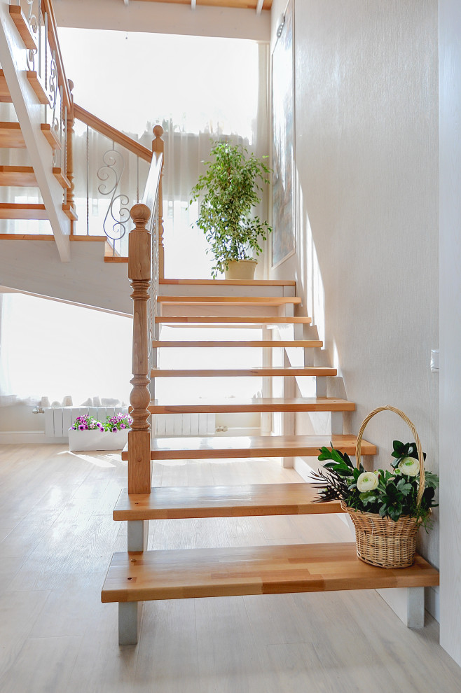 На фото: п-образная лестница среднего размера в стиле кантри с деревянными ступенями, перилами из смешанных материалов и обоями на стенах без подступенок с
