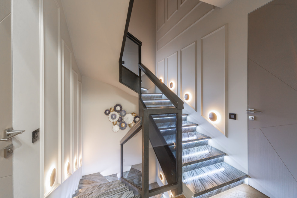 Стильный дизайн: большая п-образная лестница в стиле неоклассика (современная классика) с ступенями из плитки, подступенками из плитки и стеклянными перилами - последний тренд