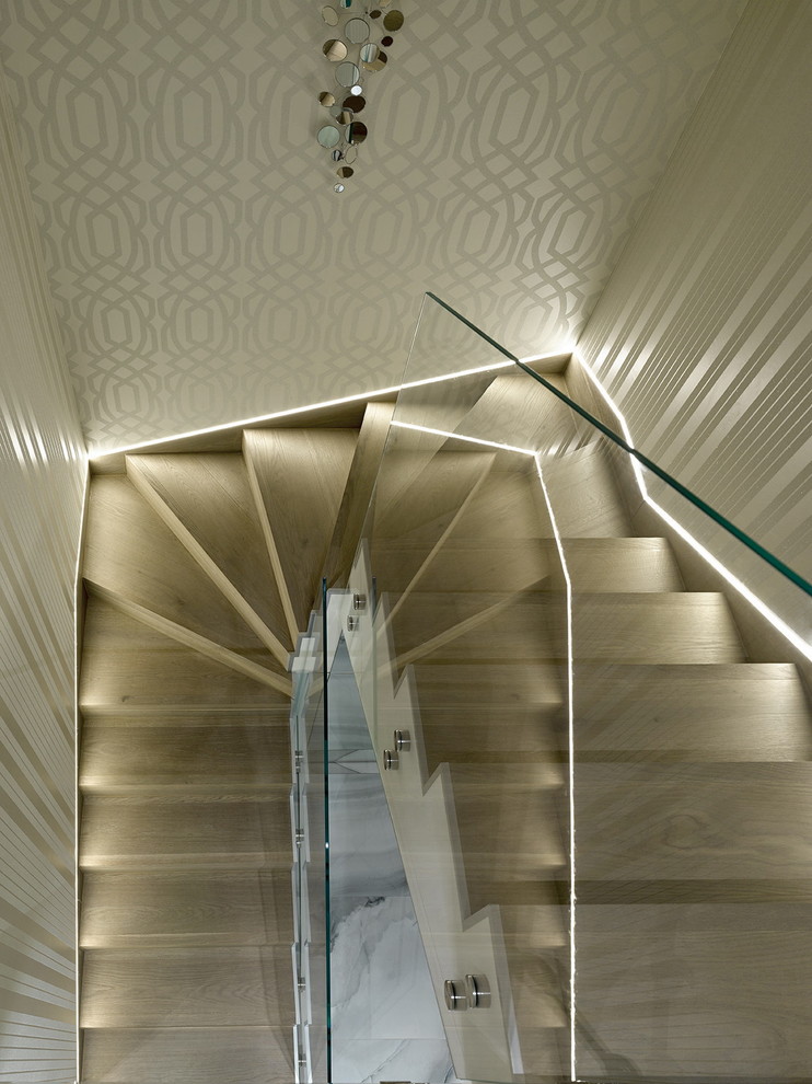 Ejemplo de escalera en U contemporánea de tamaño medio con escalones de madera, contrahuellas de madera y barandilla de vidrio