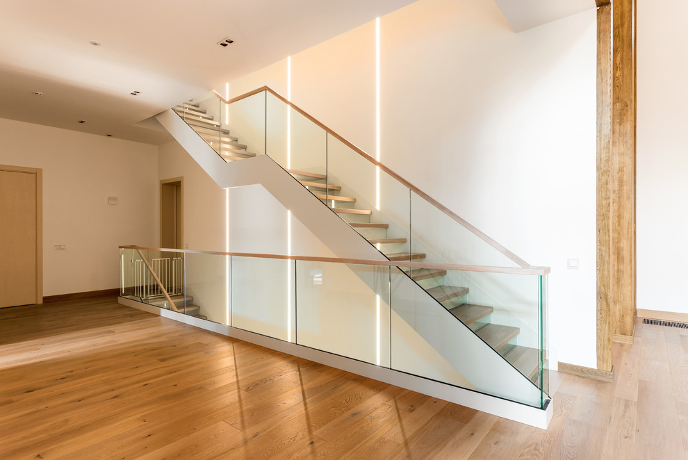 Идея дизайна: большая прямая лестница в современном стиле с крашенными деревянными ступенями, стеклянными подступенками и деревянными перилами