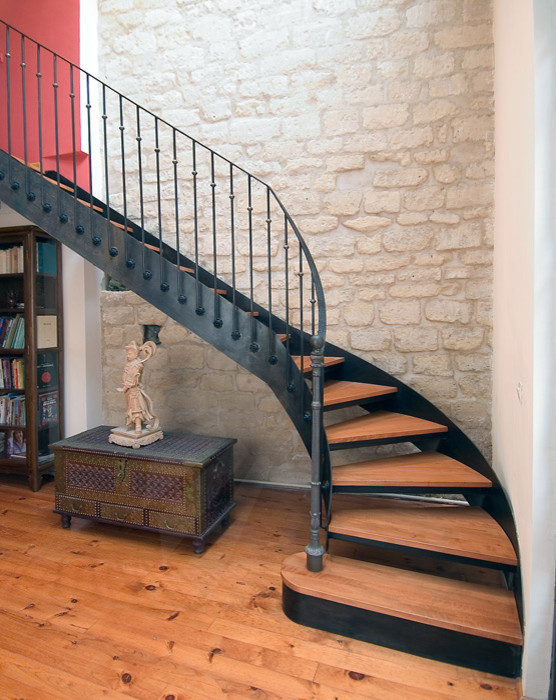 На фото: изогнутая лестница среднего размера в современном стиле с деревянными ступенями
