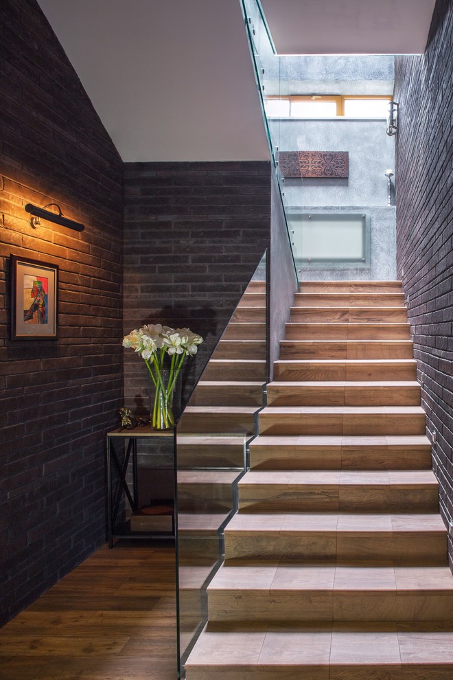 Источник вдохновения для домашнего уюта: п-образная лестница в современном стиле с ступенями из плитки, подступенками из плитки и стеклянными перилами