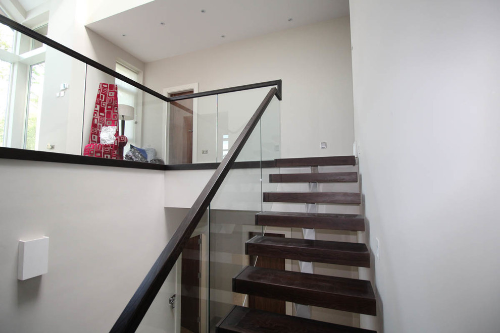 Inspiration pour un escalier droit nordique de taille moyenne avec des marches en bois et un garde-corps en verre.