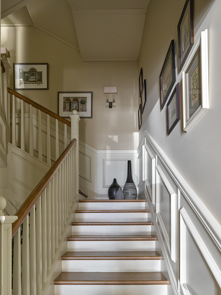 Стильный дизайн: п-образная лестница в стиле неоклассика (современная классика) с деревянными ступенями и деревянными перилами - последний тренд