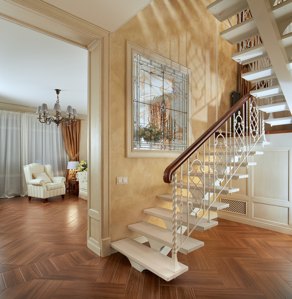 Réalisation d'un escalier sans contremarche tradition en U de taille moyenne avec des marches en bois et éclairage.