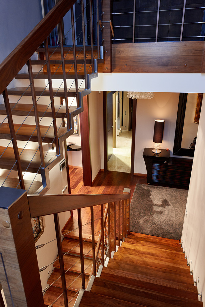 На фото: деревянная лестница в современном стиле с деревянными ступенями и деревянными перилами