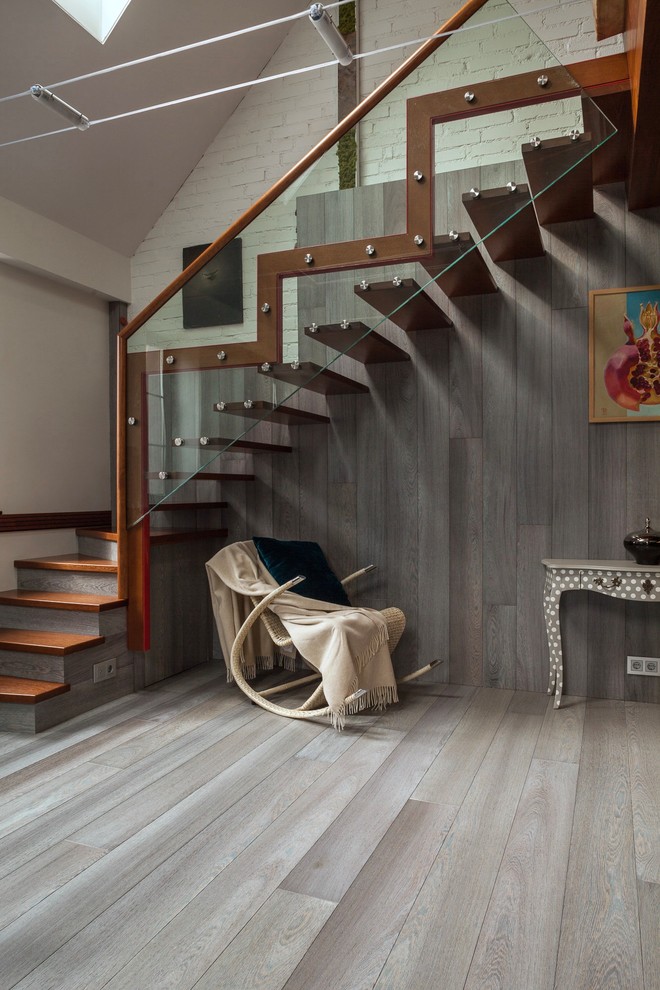 Réalisation d'un escalier courbe urbain avec des marches en bois et un garde-corps en matériaux mixtes.