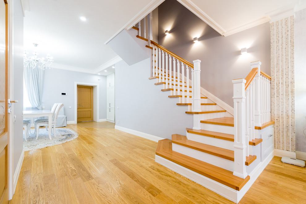 Aménagement d'un escalier classique en U de taille moyenne avec des marches en bois, des contremarches en béton et un garde-corps en bois.
