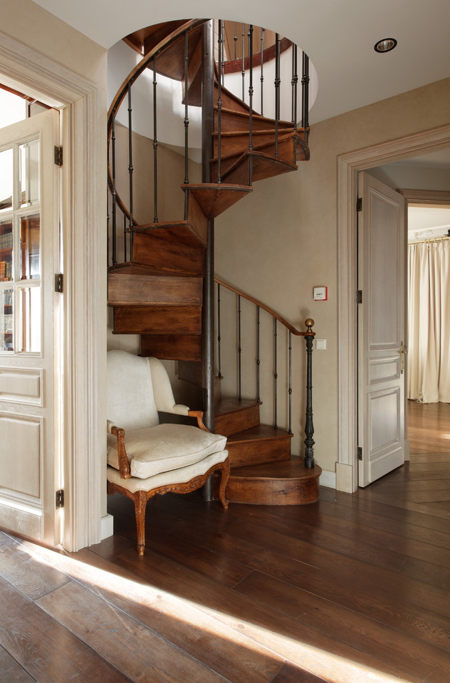 Стильный дизайн: большая винтовая деревянная лестница в классическом стиле с деревянными ступенями - последний тренд