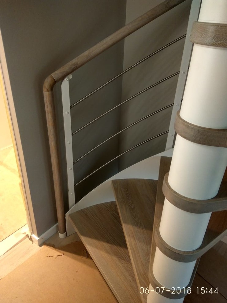 Стильный дизайн: маленькая винтовая лестница в стиле неоклассика (современная классика) с деревянными ступенями и металлическими перилами для на участке и в саду - последний тренд