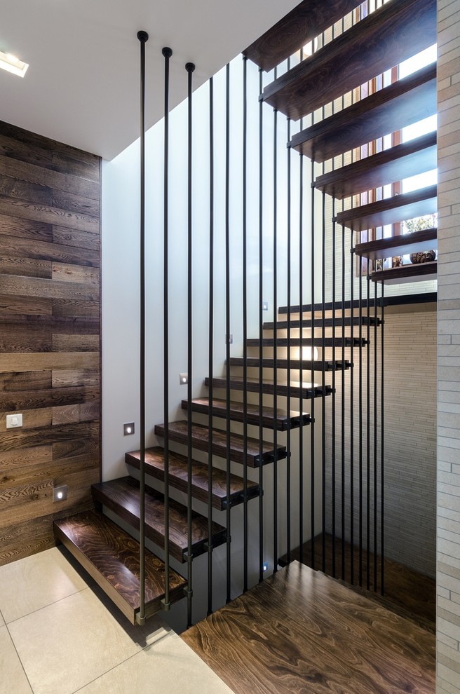 Idée de décoration pour un escalier droit design avec des marches en bois.