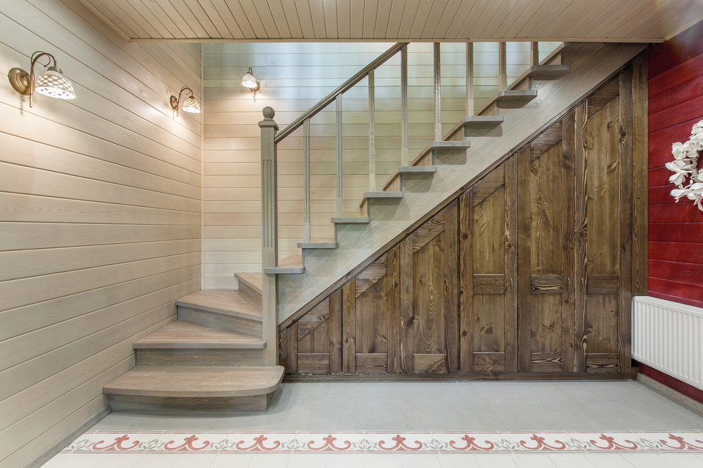 Стильный дизайн: угловая деревянная лестница в стиле кантри с деревянными ступенями - последний тренд
