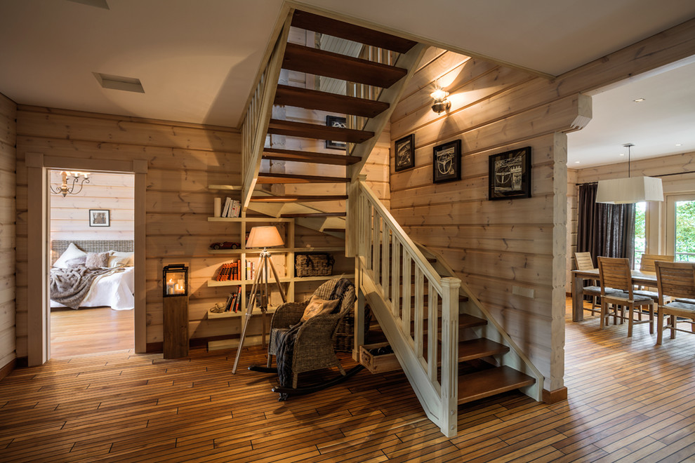 Идея дизайна: п-образная лестница в стиле кантри с деревянными ступенями и кладовкой или шкафом под ней без подступенок