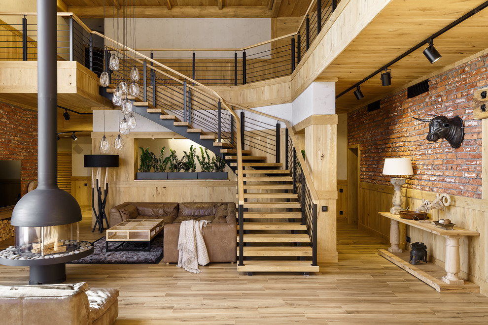 Стильный дизайн: изогнутая лестница в стиле лофт с деревянными ступенями и перилами из смешанных материалов без подступенок - последний тренд