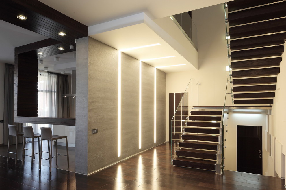 Свежая идея для дизайна: большая п-образная лестница в современном стиле с деревянными ступенями и стеклянными перилами - отличное фото интерьера