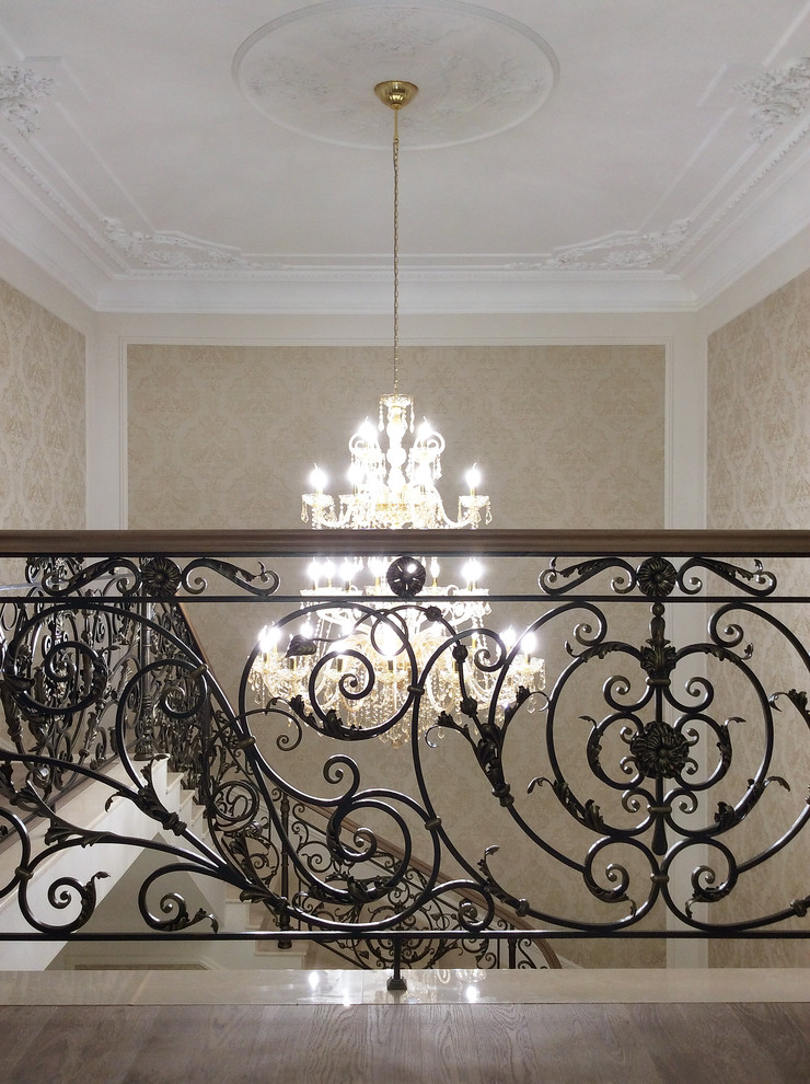 На фото: лестница в классическом стиле с мраморными ступенями, подступенками из мрамора и обоями на стенах с