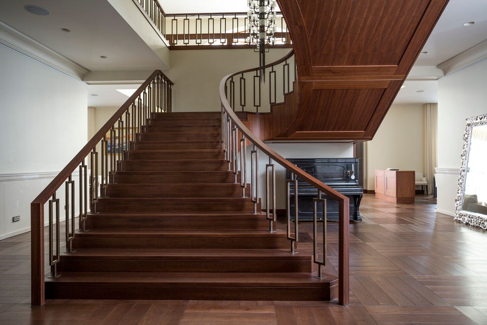 Ejemplo de escalera curva clásica renovada con escalones de madera y contrahuellas de madera