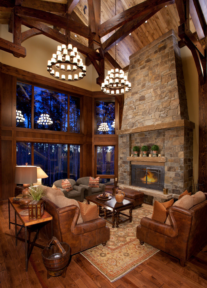 Photo of a large rustic formal open plan living room in Salt Lake City with beige walls, a standard fireplace, a stone fireplace surround, no tv, medium hardwood flooring and brown floors.